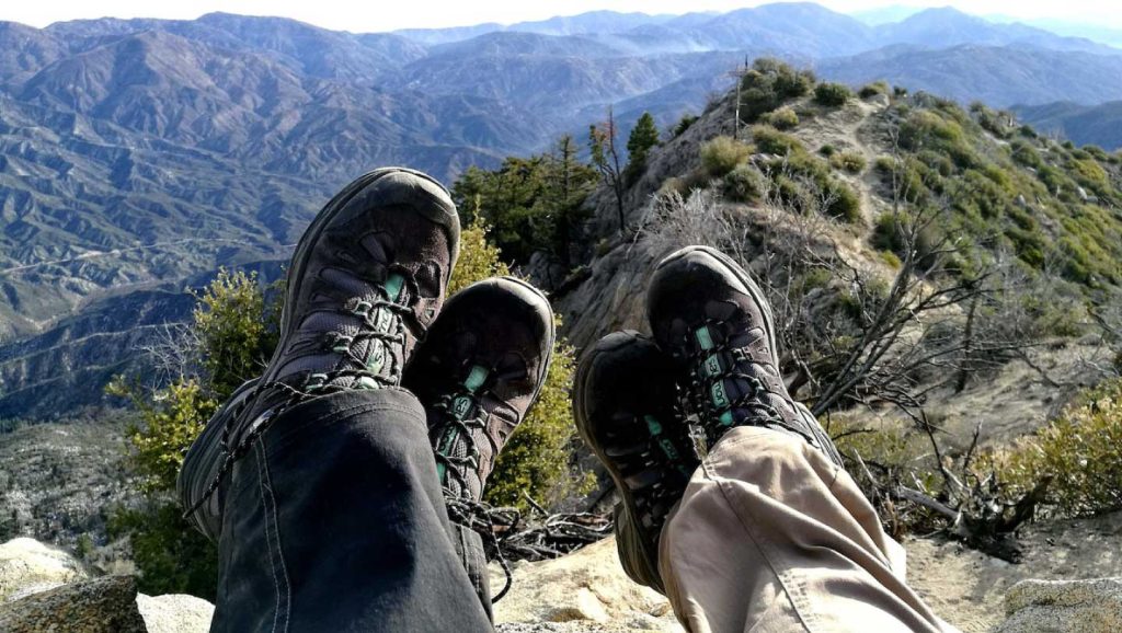 hiking boots in foreground with scenic mountains in background